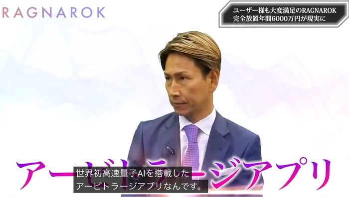 動画の一場面。画面いっぱいに「アービトラージアプリ」と表示され、字幕に「世界初高速量子AIを搭載したアービトラージアプリなんです。」と出ている